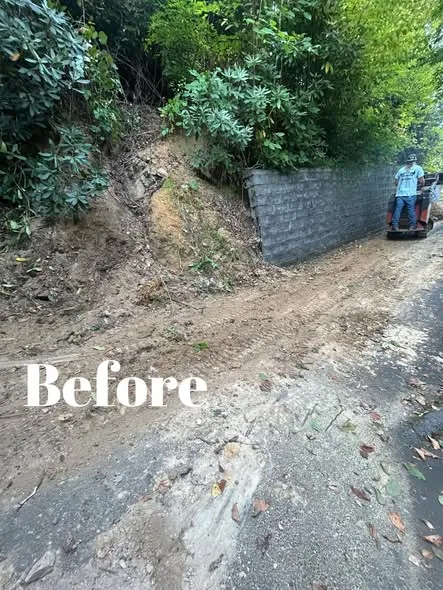 Eroded dirt bank beside a driveway before the retaining wall